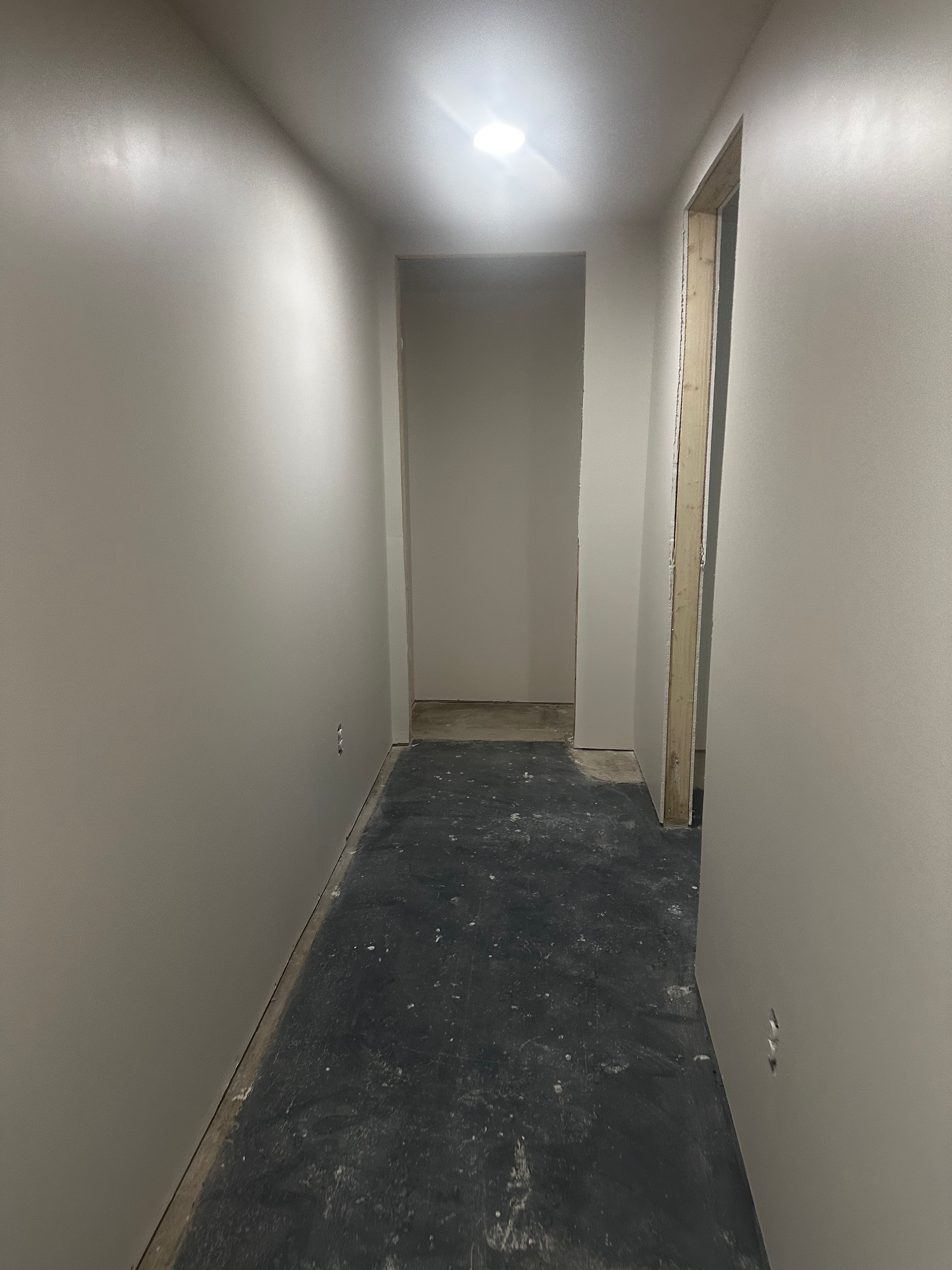 The same basement hallway before finished flooring and trim