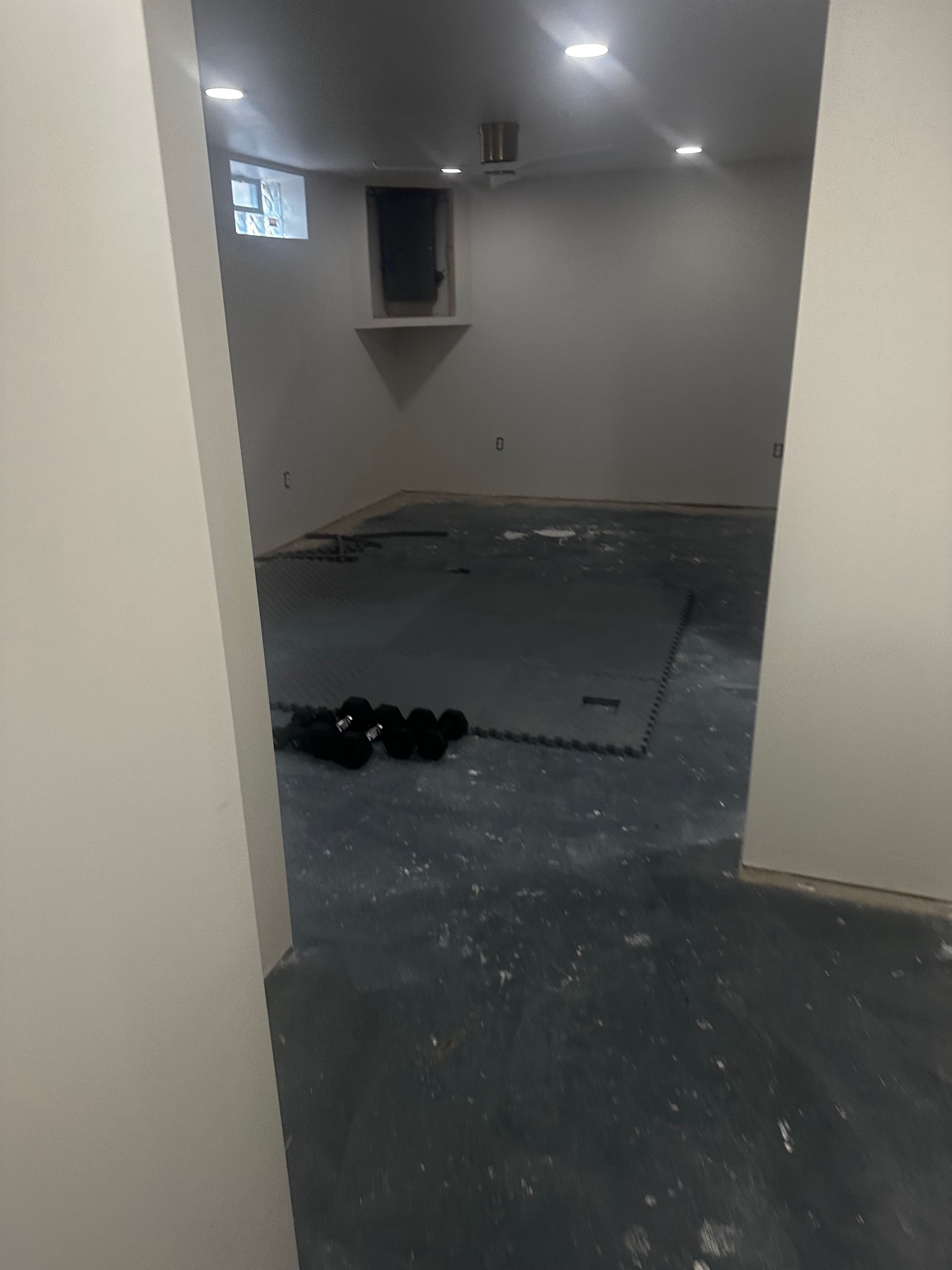 The same basement bedroom viewed from its doorway before finishing